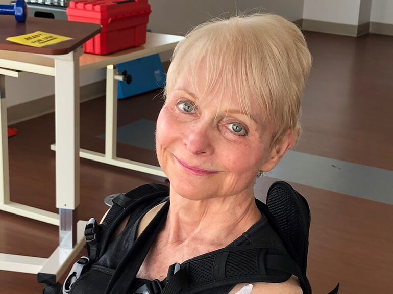Judy smiling and wearing her back brace during her therapy.
