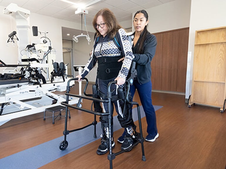 A women wearing advanced rehabilitation technology works to walk again after spinal cord injury.