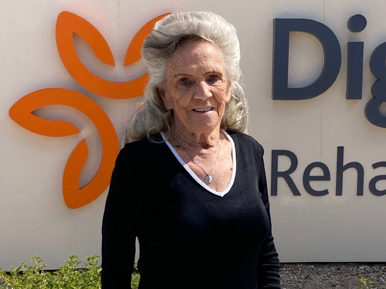 Shelby posing for a photo outside in front of the Dignity Health Hospital sign.