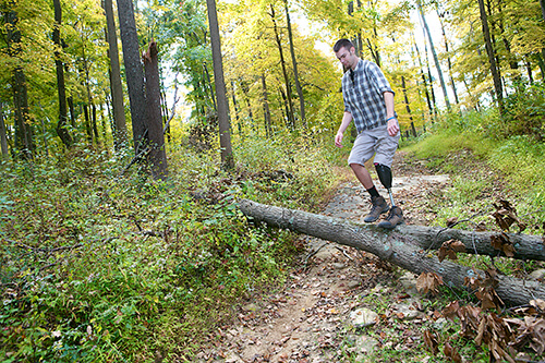 Eric, an amputee, is hiking in the forest