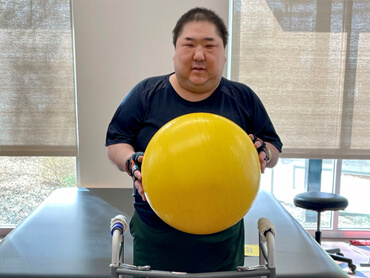 Joseph Lo holding  a therapy ball.
