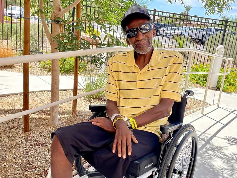 Ralph McKinney smiles in his wheelchair.